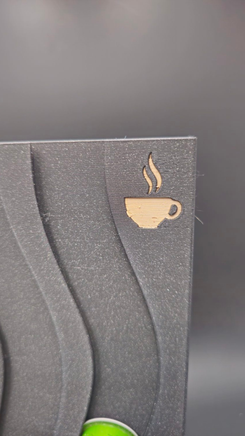 Détail du logo tasse de café gravé en haut du panneau